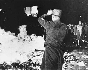 A member of the SA throws confiscated books into the bonfire during the public burning of "un-German" books on the Opernplatz in Berlin, May 10, 1933
