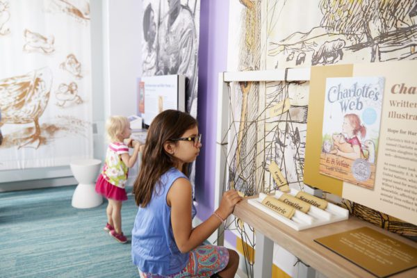 A young girl plays a word choice game in the children's literature gallery at the American Writers Museum in Chicago