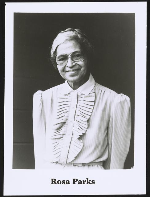 Photograph shows a half-length portrait of Rosa Parks, standing, facing front.