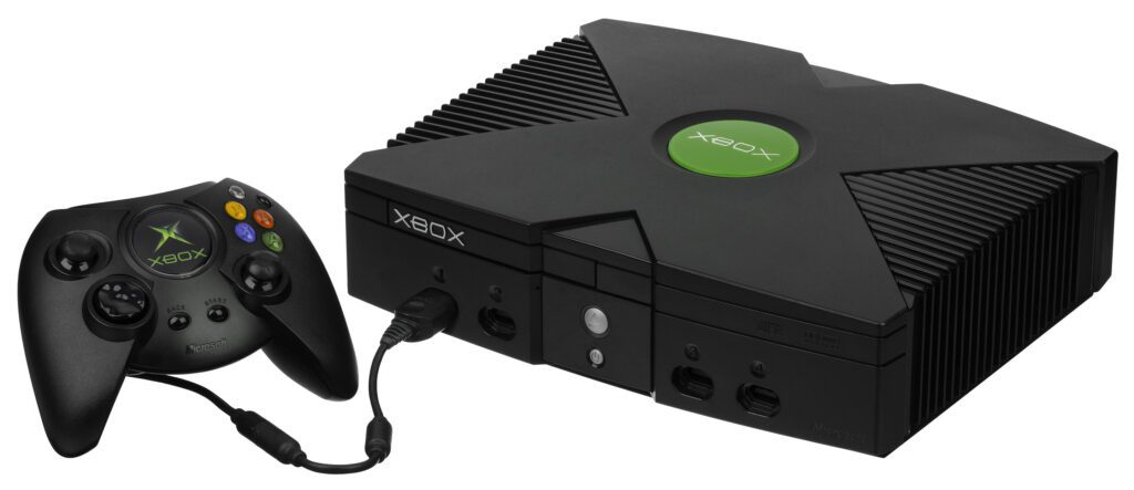 A black Xbox console with one black Duke-style controller plugged into it.